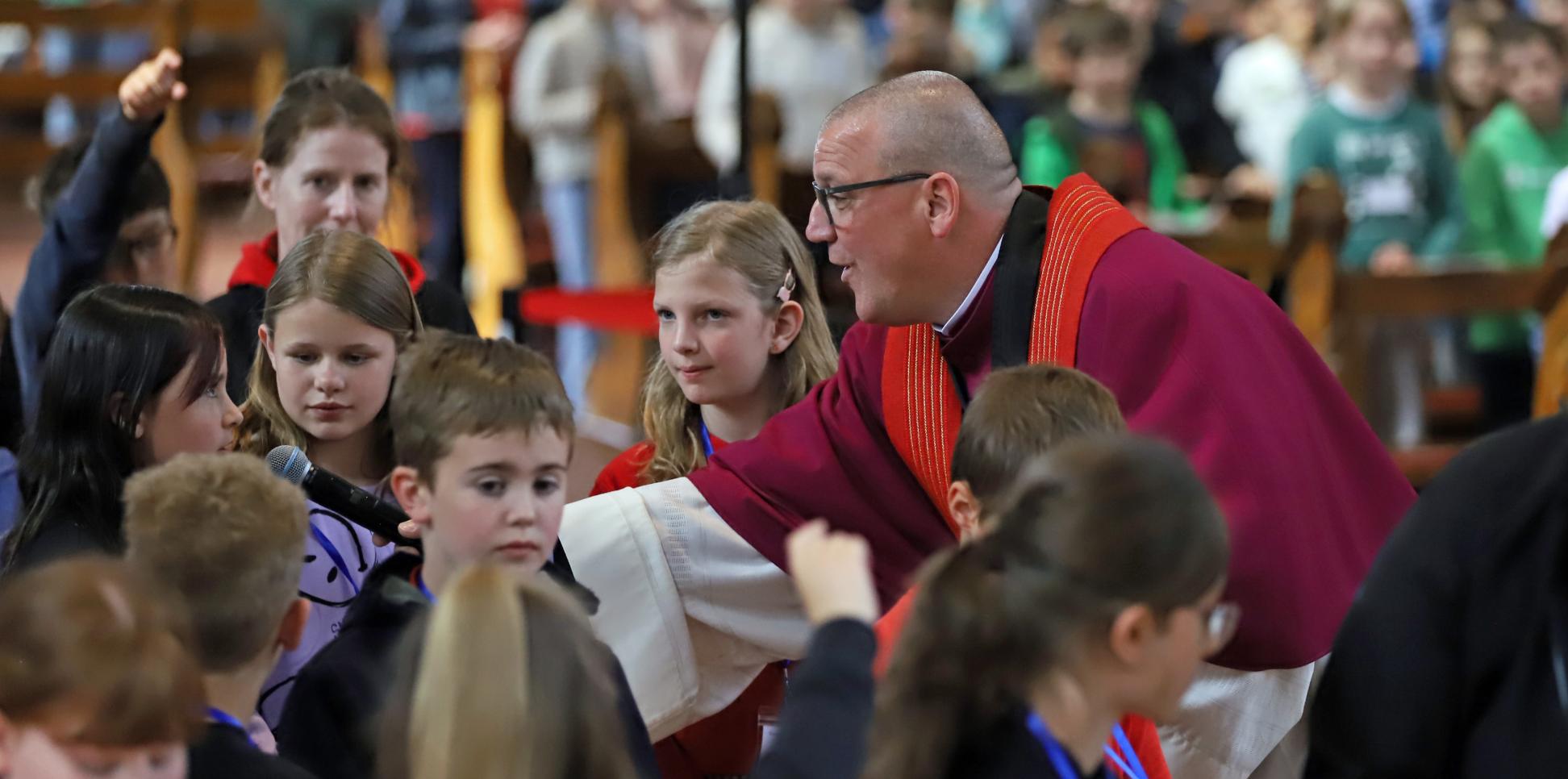 Domkapitular Matthias Struth mit Kindern beim Gottesdienst anlässlich der Heilig-Rock-Tage 2025.