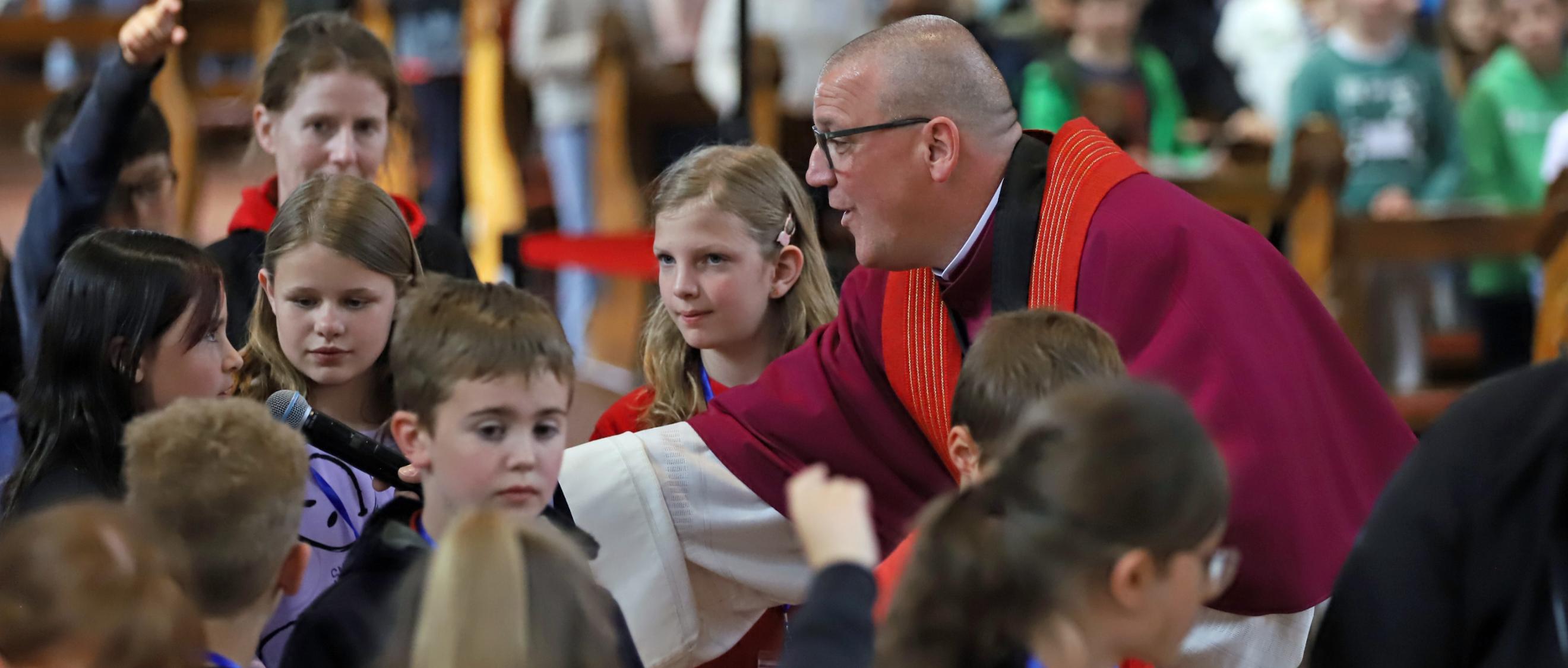 Domkapitular Matthias Struth mit Kindern beim Gottesdienst anlässlich der Heilig-Rock-Tage 2025.