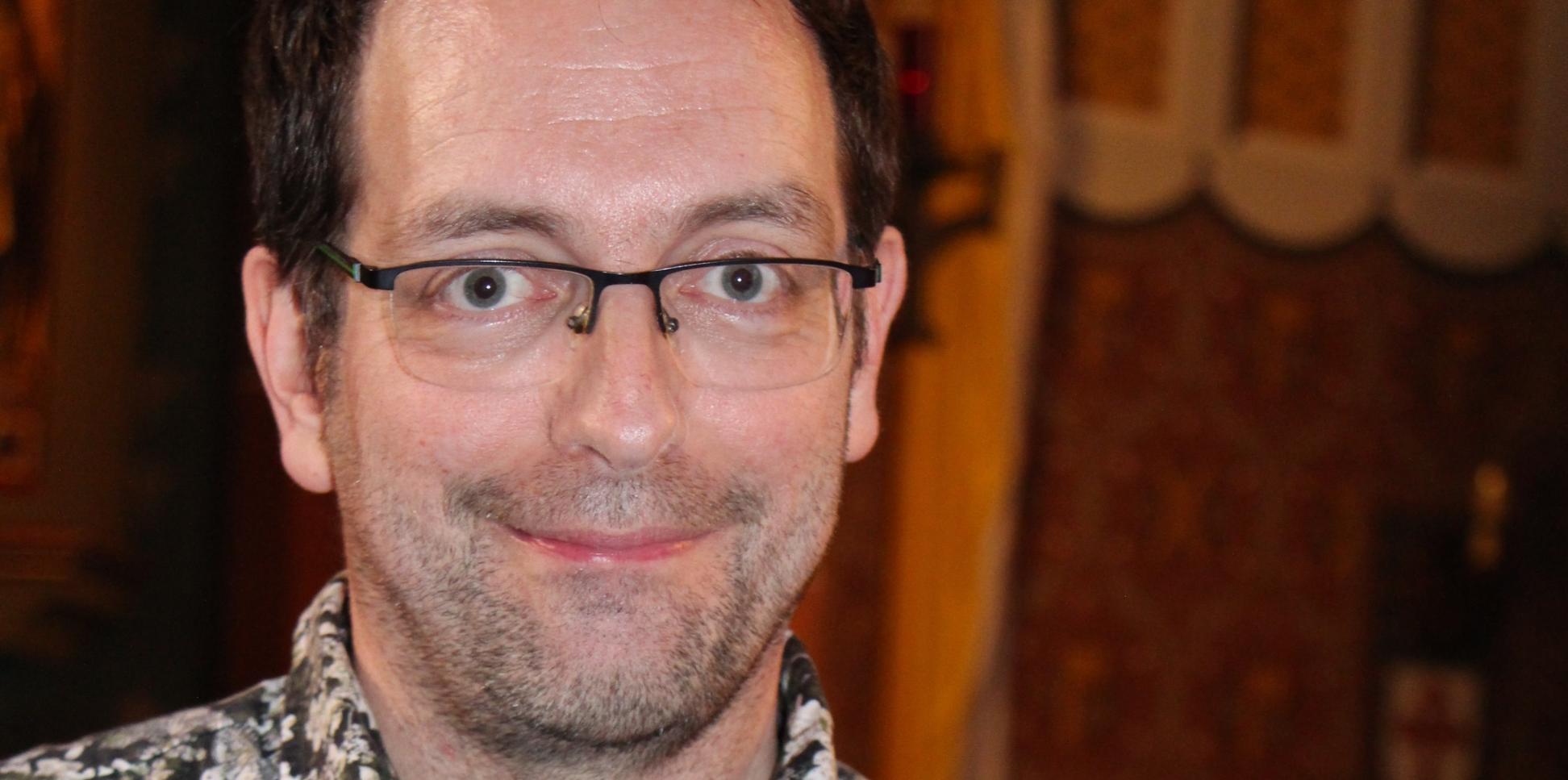 Ein Mann mit Brille lächelt in die Kamera