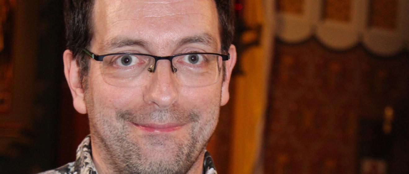 Ein Mann mit Brille lächelt in die Kamera