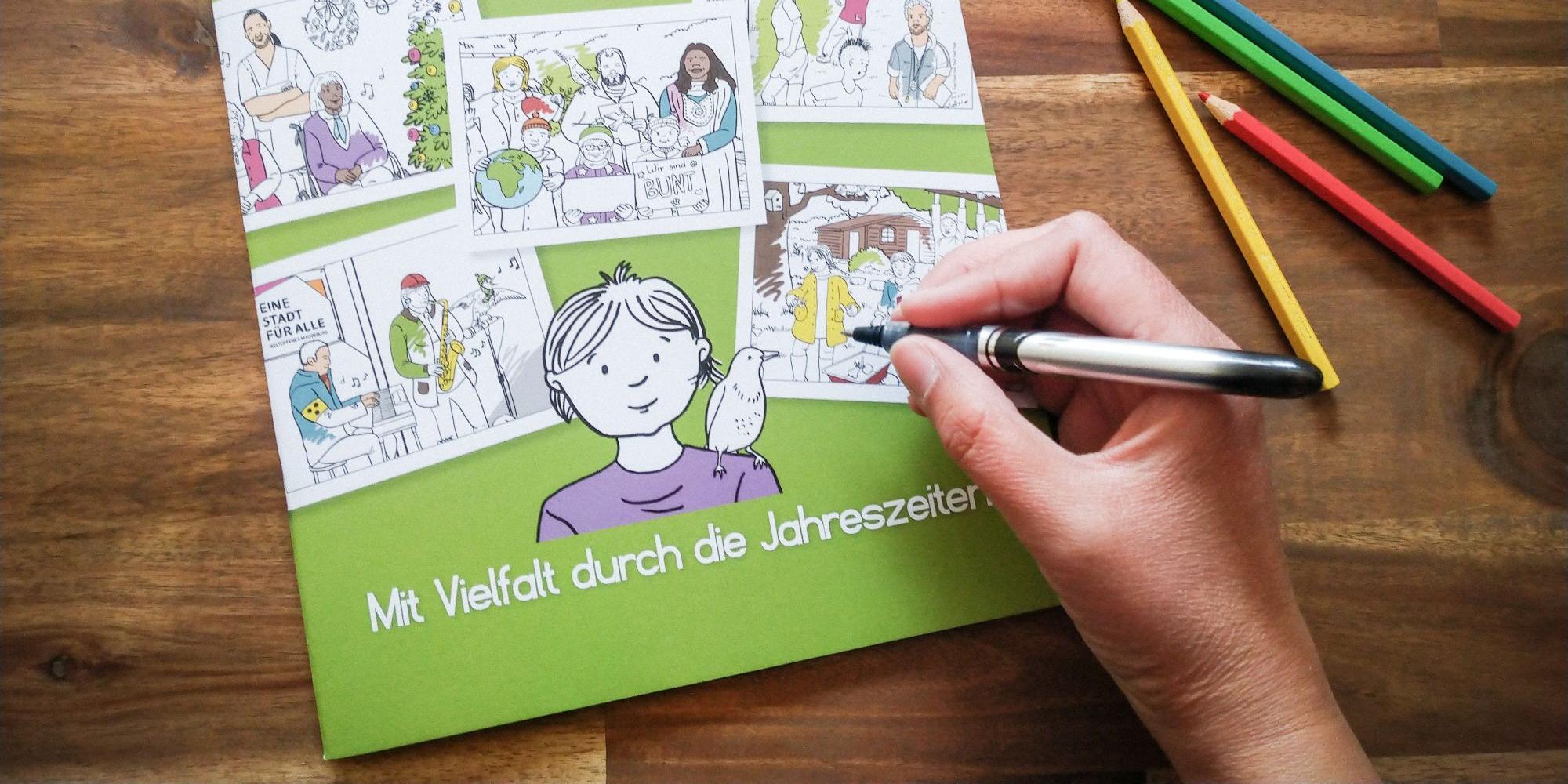 Eine Person bemalt ein Heft der Katholischen Erwachsenenbildung in Sachsen-Anhalt, das Teil von „Kirche für Demokratie“ ist.