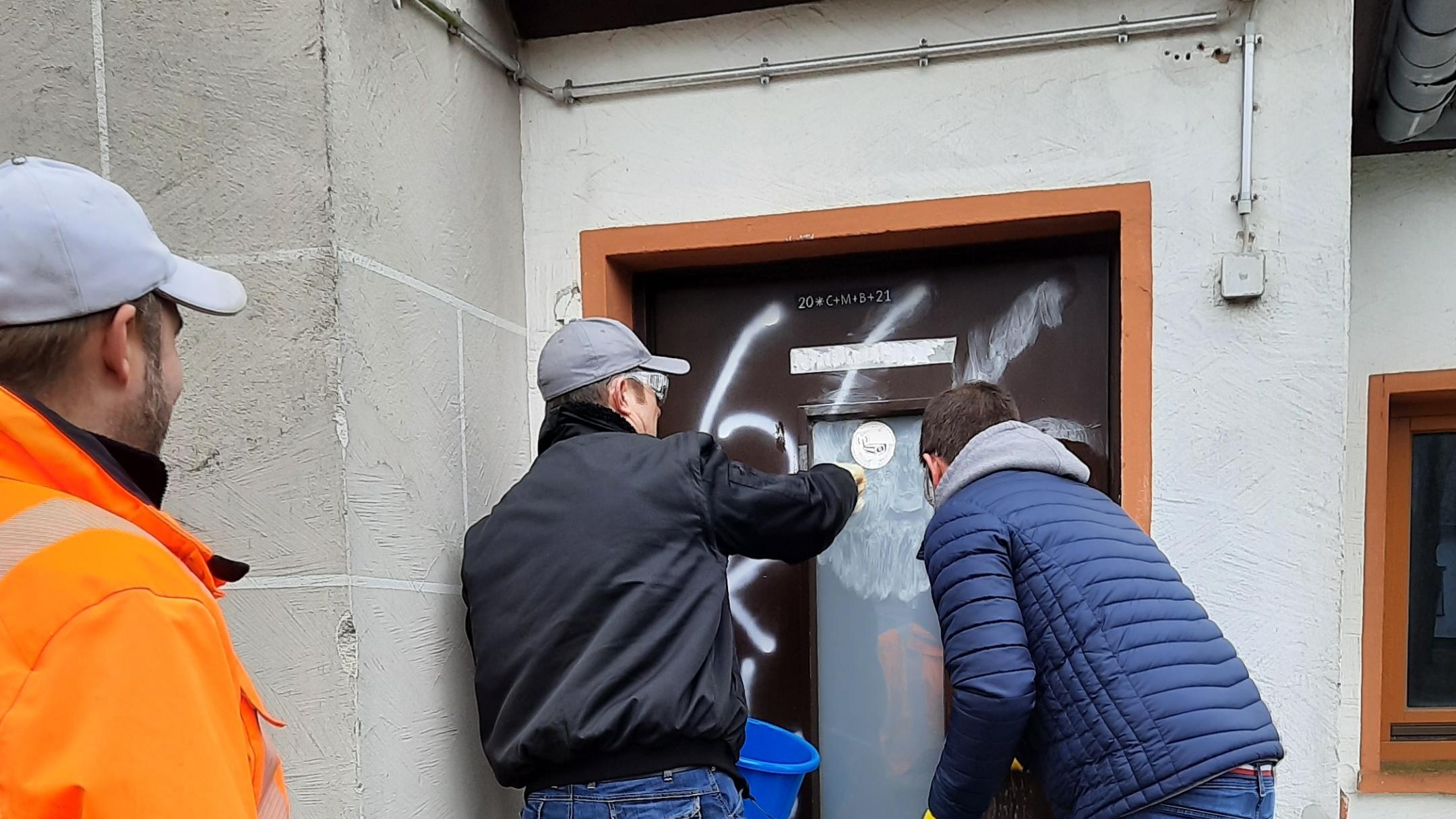 Helfer beseitigen die Spuren des Vandalismus.