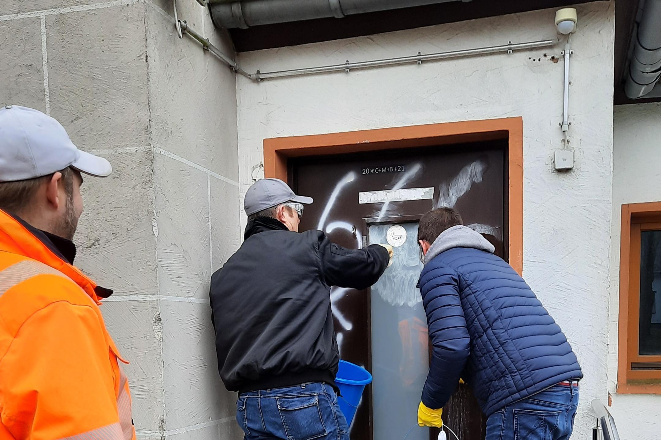 Helfer beseitigen die Spuren des Vandalismus.