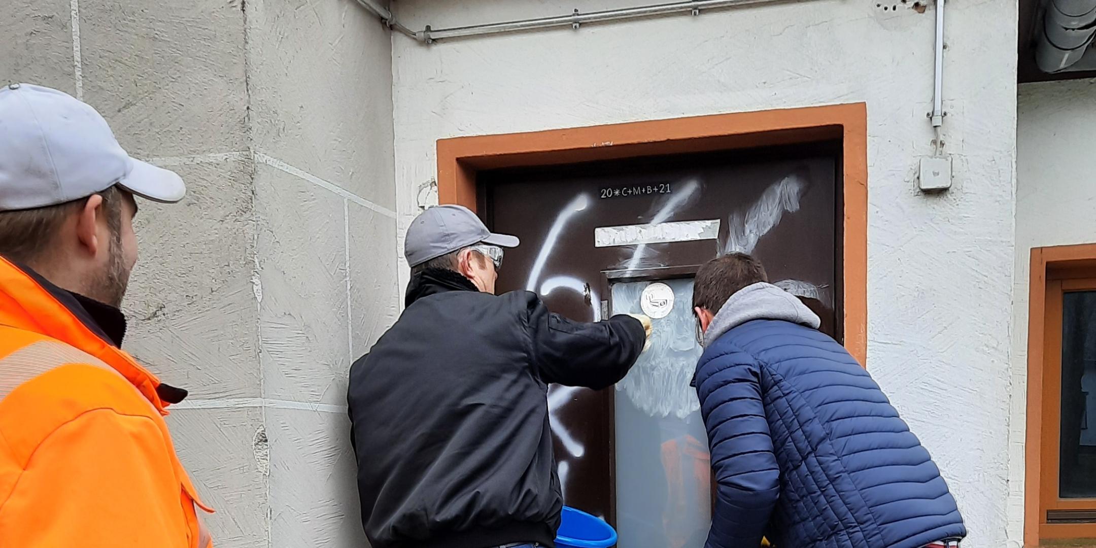 Helfer beseitigen die Spuren des Vandalismus.